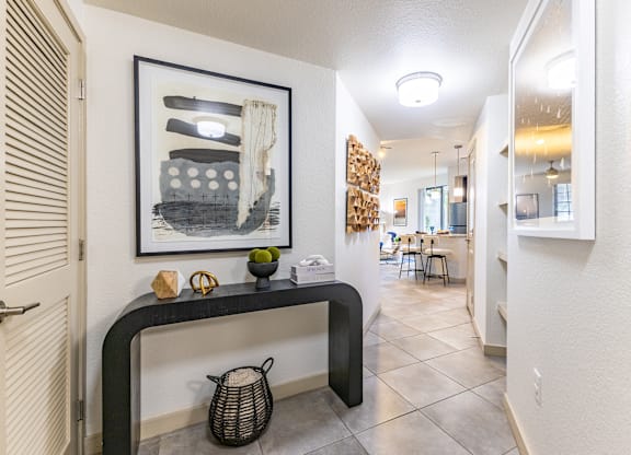 A hallway with a black and white painting on the wall.