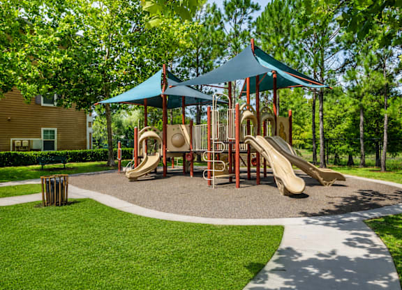 A playground with a blue canopy and a yellow slide.