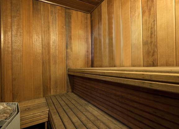 A wooden sauna with benches and a table.