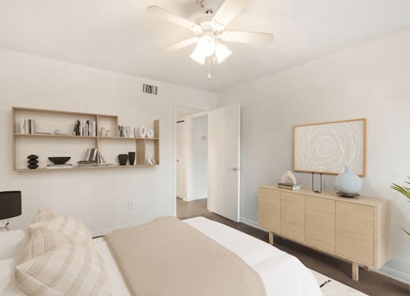 A bedroom with a bed, a dresser, and a ceiling fan.
