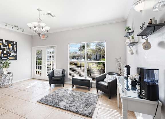 A living room with a grey rug and a black and white painting on the wall.
