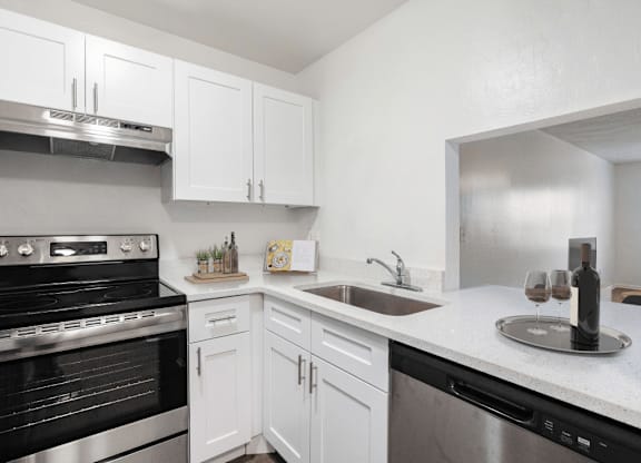 A kitchen with white cabinets and a black oven.