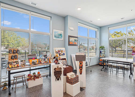 a room with large windows and a table with chairs