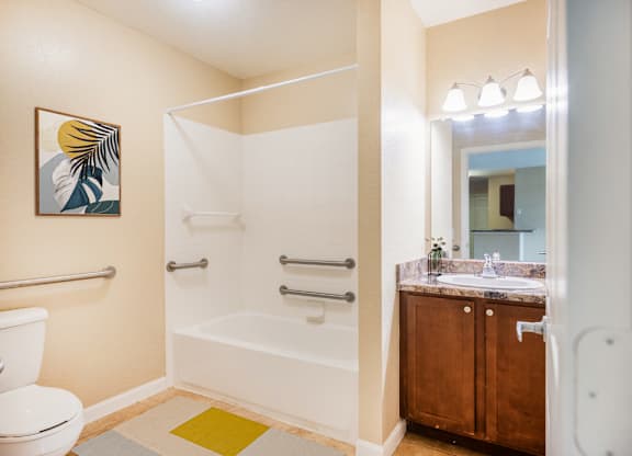 A bathroom with a toilet, a bathtub, a sink and a mirror.