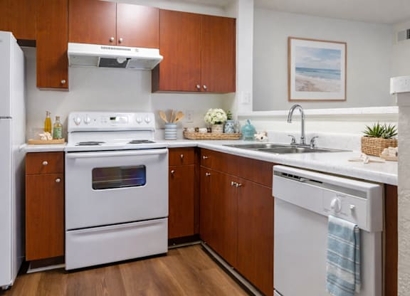 A kitchen with white appliances and wooden cabinets.