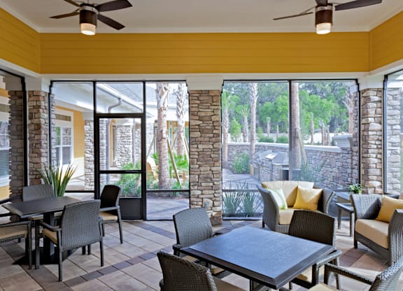 A patio with a table and chairs is surrounded by a stone wall.