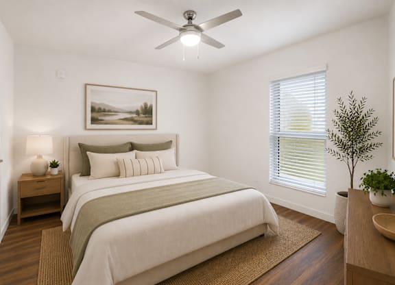 A bedroom with a large bed and a ceiling fan.