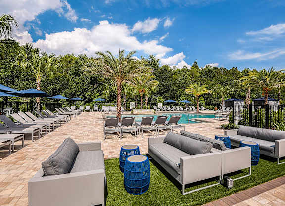 A poolside area with lounge chairs and umbrellas.