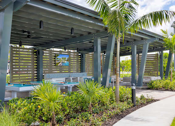 Covered Veranda with Outdoor Games at Everly Apartments in Naples, FL