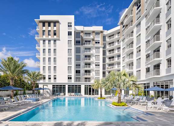 Expansive sun deck with heated pool and loungers at The Marc Apartments in Palm Beach Gardens FL
