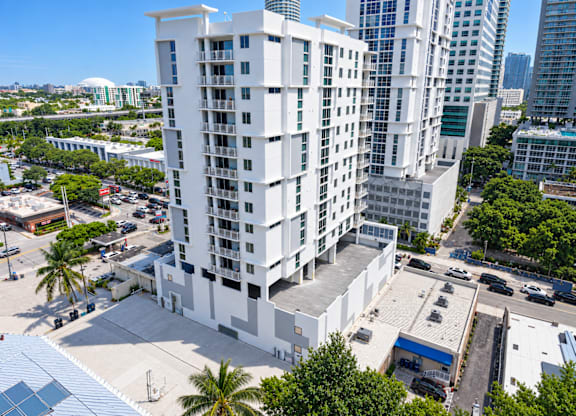 A white building with a blue awning is in the foreground of a city scene.