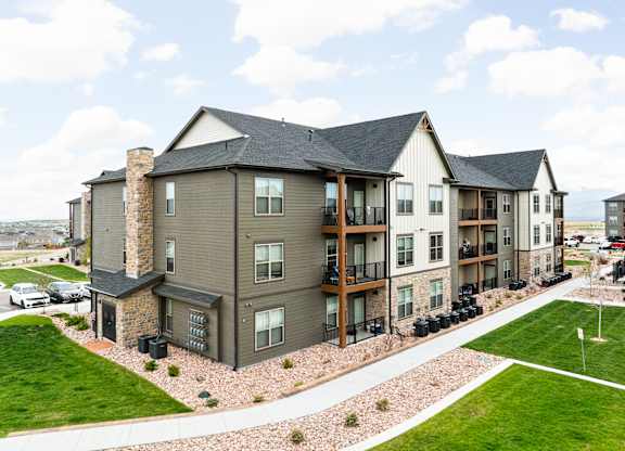 an aerial view of an apartment building with green grass and a parking lot