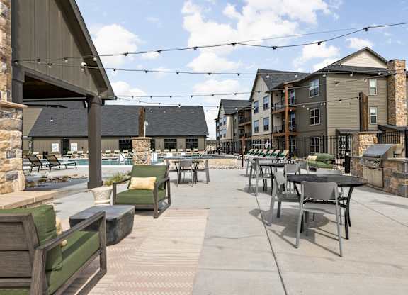 an outdoor patio with tables and chairs at the residences at town center apartments