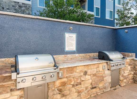 A stone wall with a grill and a sign on it.