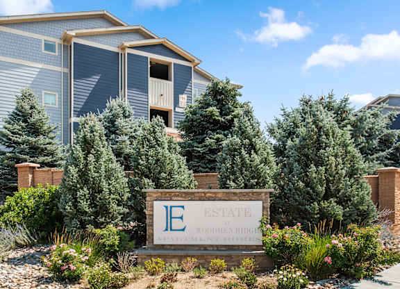 A sign in front of a building that says Estate.