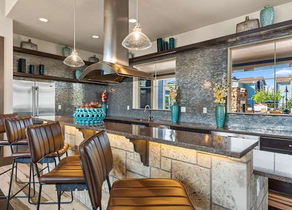 A kitchen with a bar area and chairs.