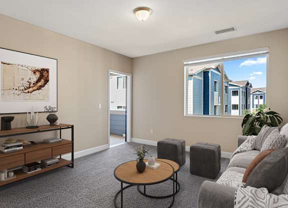 A living room with a grey sofa, a coffee table, and a painting on the wall.