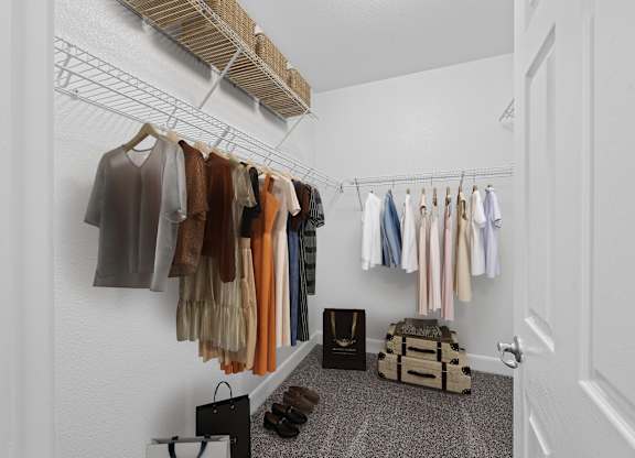 A hallway with clothes hanging on a rack and a bag on the floor.