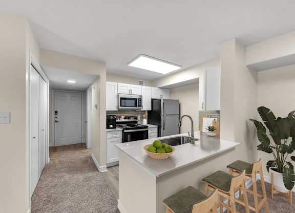 A kitchen with a refrigerator, stove, and sink.