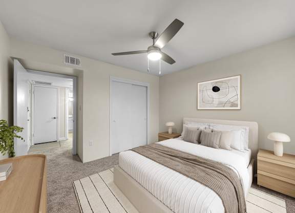 A bedroom with a large bed and a ceiling fan.