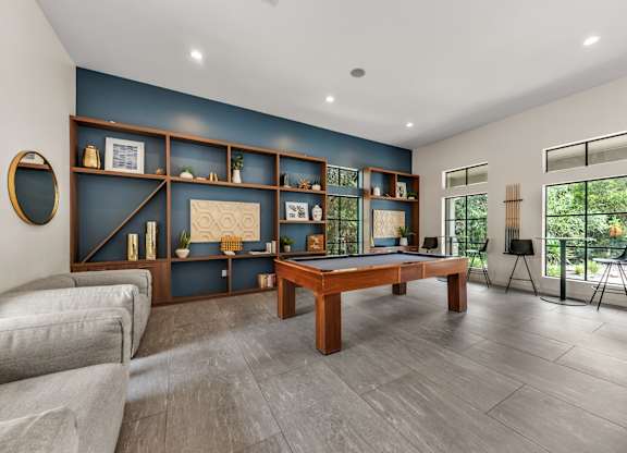 A room with a pool table and a couch.