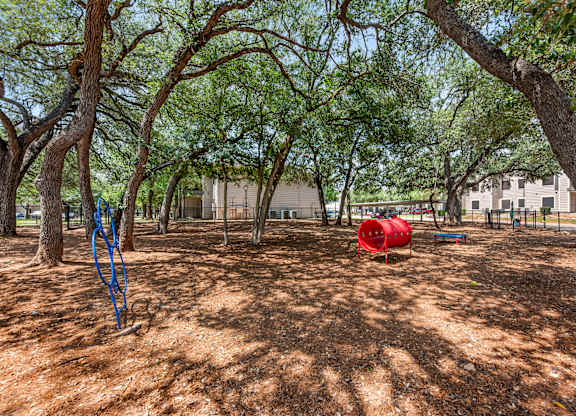 A dog park with a red barrel.