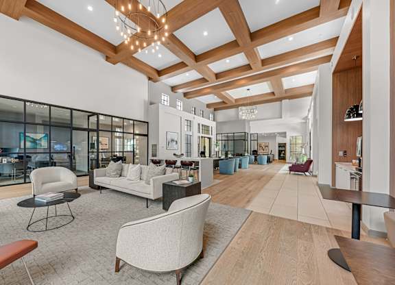 A spacious living room with a high ceiling and wooden beams.