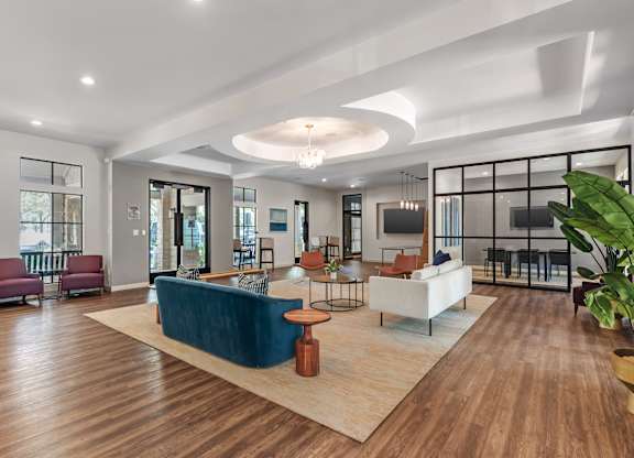 A modern living room with a blue sofa and wooden floors.