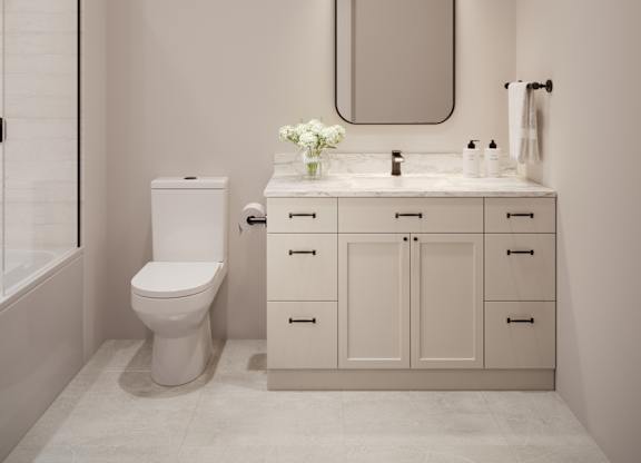 A white bathroom with a toilet, sink, and mirror.