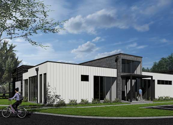 A modern building with a white exterior and a person riding a bicycle in front of it at  Aerie Heartwood Preserve in Omaha, NE