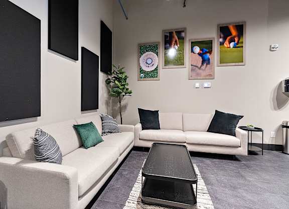 A living room with a white couch, a black coffee table, and a grey rug.at Raymond Block, Alberta