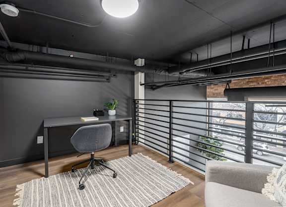 A modern home office with a desk, chair, and a window with blinds.at Raymond Block, Alberta, T6E 3R7