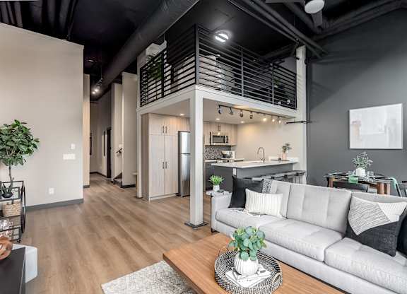 A modern living room with a grey sofa and a wooden coffee table.at Raymond Block, Edmonton, AB