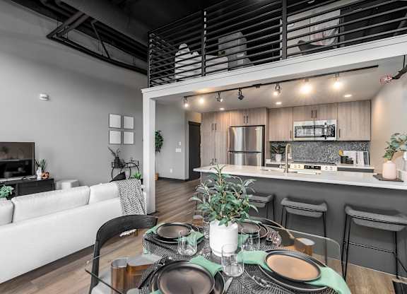 A modern dining area with a table set for a meal.at Raymond Block, Edmonton, T6E 3R7
