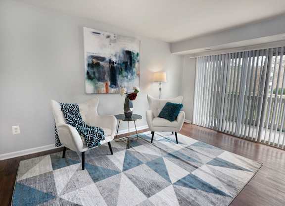 a living room with two chairs and a rug at The Glendale Residence, Lanham, MD, 20706