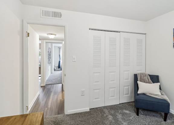 a living room with white doors and a blue chair at Oaks at Oxon Hill, Oxon Hill, Maryland