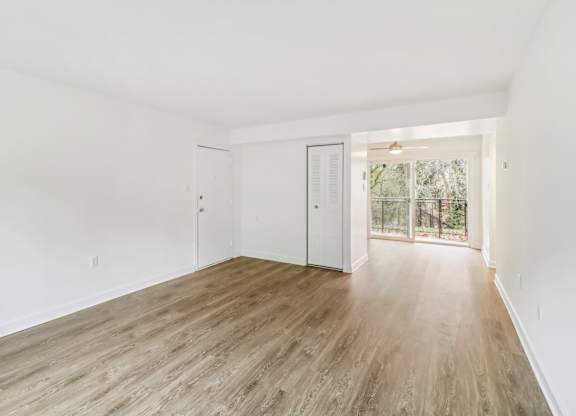 an empty living room with white walls and wood floors at Oaks at Oxon Hill, Oxon Hill, Maryland