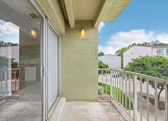 a balcony with a view of a brick wall and a glass door at Andrews Ridge Apartments, Suitland, MD