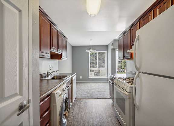 a kitchen with white appliances and wooden cabinets at Andrews Ridge Apartments, Suitland, MD