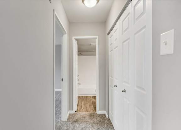 a bedroom with white doors and a hallway with a door to a closet at Andrews Ridge Apartments, Suitland, MD