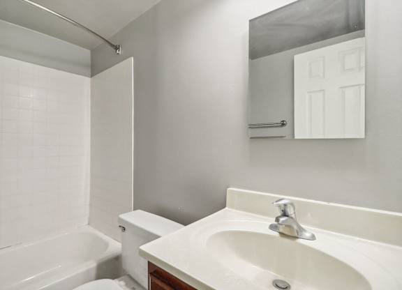 a bathroom with a sink and a toilet and a tub at Andrews Ridge Apartments, Suitland, MD