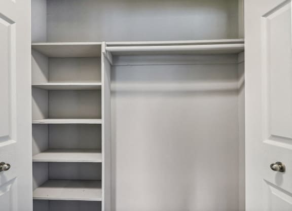 a closet with white shelves and a white door at Andrews Ridge Apartments, Suitland, MD