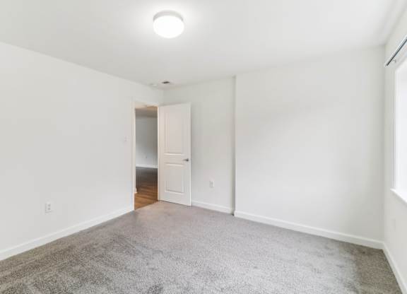 a living room with a carpeted floor and white walls at Oaks at Oxon Hill, Oxon Hill, Maryland