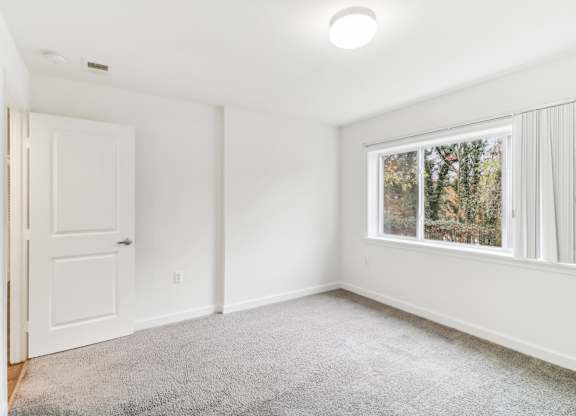 an empty room with a window and a door at Oaks at Oxon Hill, Oxon Hill, Maryland