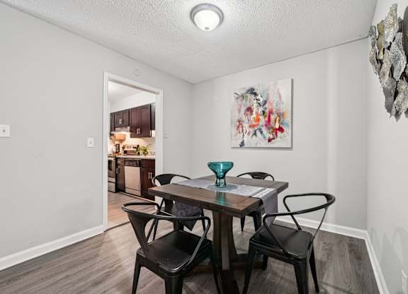 A dining room with a table and chairs.