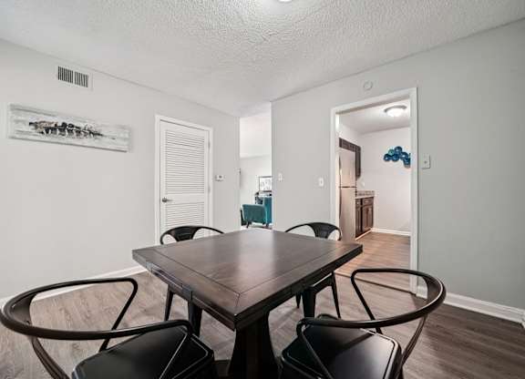 A dining room with a wooden table and chairs.