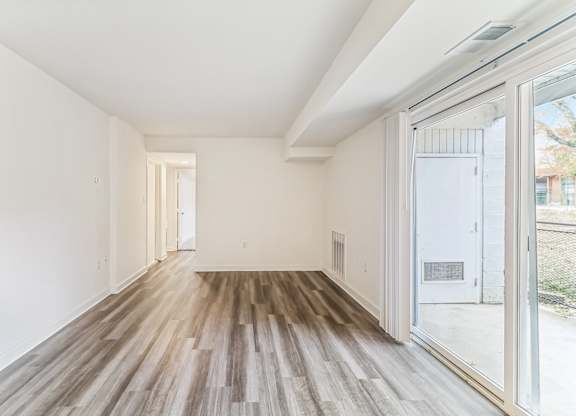 a living room with wood floors and a large glass door at Oaks at Oxon Hill, Oxon Hill, Maryland