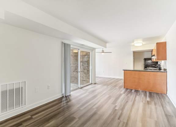 a living room with a wood floor and a sliding glass door at Oaks at Oxon Hill, Oxon Hill, Maryland