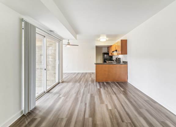 a living room and kitchen with wood floors and a sliding glass door at Oaks at Oxon Hill, Oxon Hill, Maryland