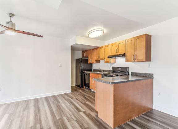 a kitchen with wooden cabinets and a counter top and a stove and refrigerator at Oaks at Oxon Hill, Oxon Hill, Maryland